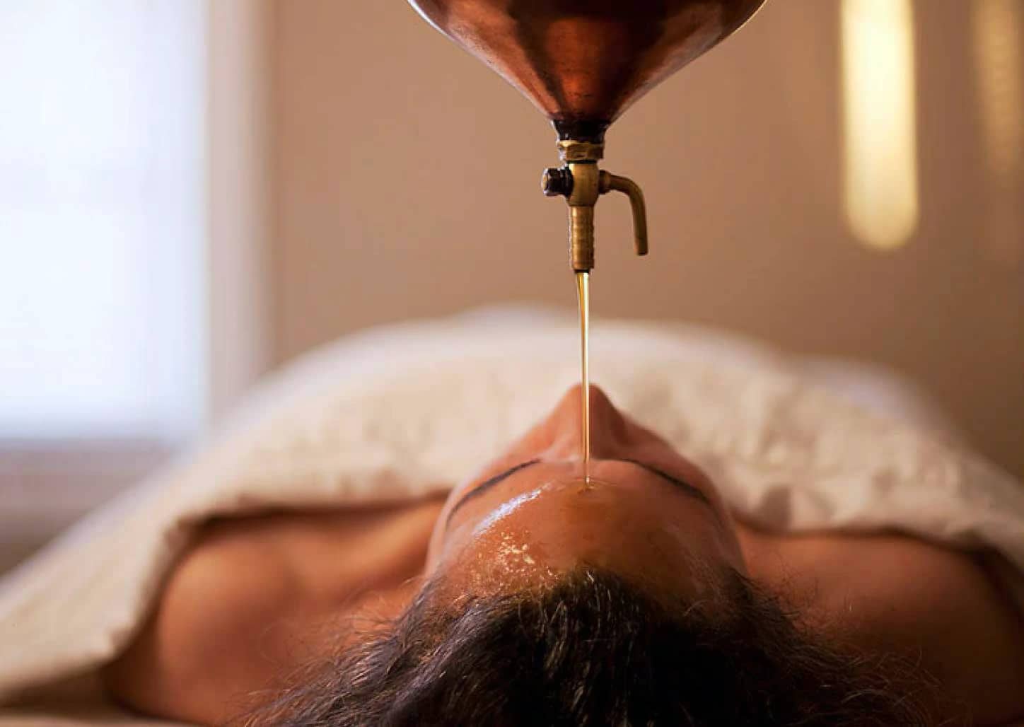 Massage relaxant avec huile chaude tombant sur le front, détente et bien-être